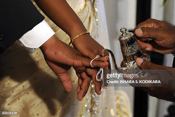 Lifestyle-SriLanka-weddings" by Mel Gunasekera A Sri Lankan priest pours holy water on the bride and bridegroom to signfiy their union at a lavish...