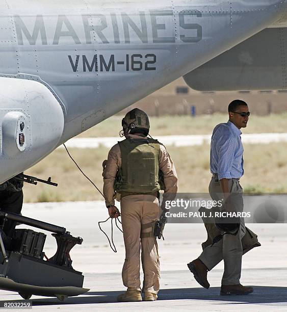 Democratic presidental candidate Barack Obama carries his helmet and body armor as he steps off a Osprey tilt-rotor aircraft at Amman, Jordan's Marka...