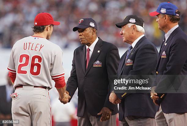 National League All-Star Chase Utley of the Philadelphia Phillies shakes the hand of former MLB player Rod Carew of the Minnesota Twins as Bill...