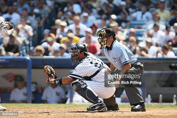 Jorge Posada of the New York Yankees and home-plate umpire James Hoye await the pitch during the game against the Oakland Athletics at Yankee Stadium...