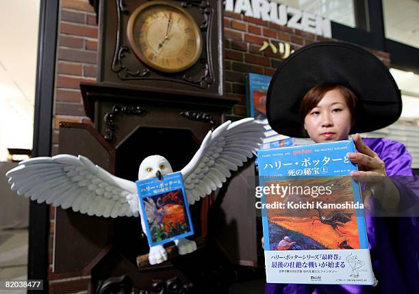 Japanese woman in a wizard costume poses with a copy of the Japanese version of "Harry Potter and the Deathly Hallows" at Maruzen Bookstore on July...