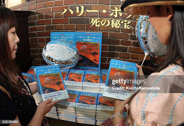Japanese Harry Potter fans pick up copies of the Japanese version of "Harry Potter and the Deathly Hallows" at Maruzen Bookstore on July 23, 2008 in...