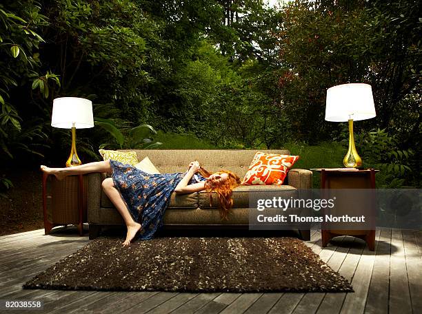 teenage girl lounging on sofa outdoors - lying on back girl on the sofa imagens e fotografias de stock