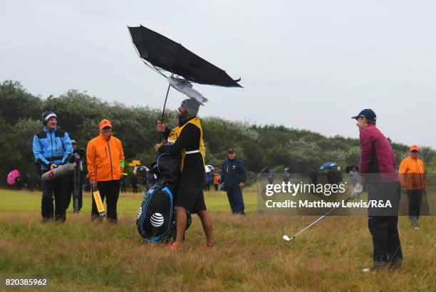 Jordan Spieth's caddie Michael Greller struggles with his umbrella during the second round of the 146th Open Championship at Royal Birkdale on July...