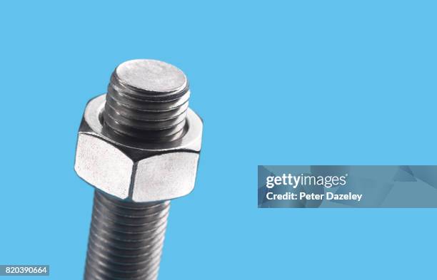 nut and bolt on blue - screws nuts bolts stock pictures, royalty-free photos & images