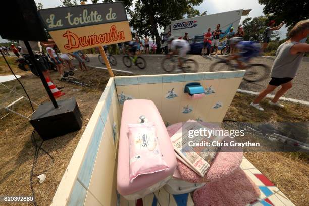 Cyclists pass a fake toilet with a sign that reads 'La Toilette du Dumoulin' during stage 19 of the 2017 Le Tour de France, a 222.5km stage from...