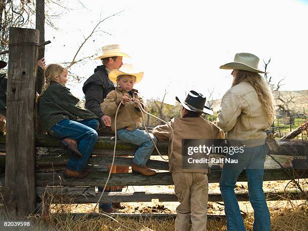 kids sitting on fence - montana western usa stockfoto's en -beelden