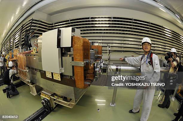 Worker shows to members of the media the facilties of the world's largest scale synchrotron 500m in diameter which produces neutrons and neutrino and...