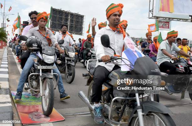 Worker inadvertently crushes a hoarding of BJP President Amit Shah under the wheels of his motor-cycle while leading the cavalcade from airport to...