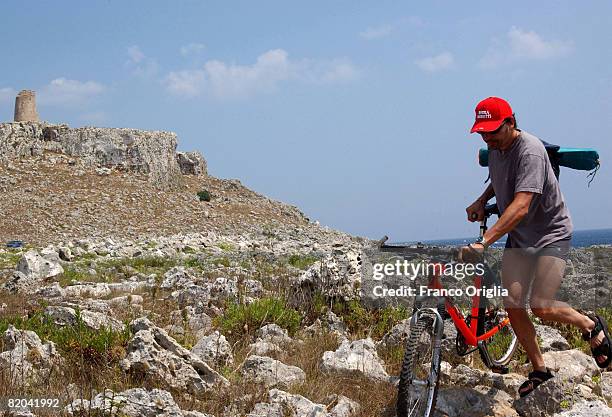 Man walks on the rocks at Sant'Emiliano's tower on August 13 in Salento, Italy. Salento is that strip of land that forms the heel of the boot . It is...