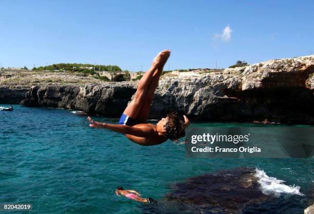 Boy dives from Santa Maria di Leuca's Bay on August 12 in Salento, Italy. Salento is that strip of land that forms the heel of the boot . It is...