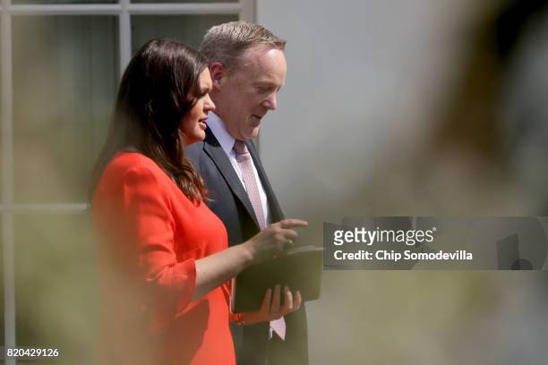 White House Press Secretary Sean Spicer and Principal Deputy Press Secretary Sarah Huckabee Sanders walk out of the White House July 21, 2017 in...