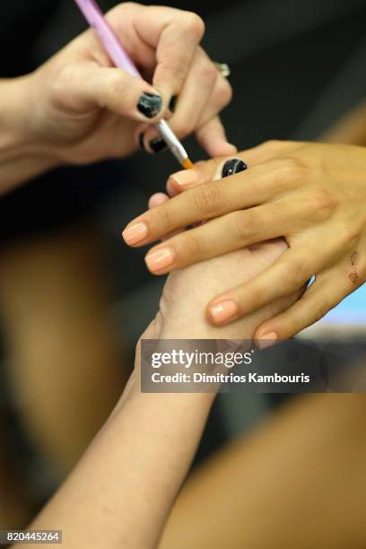 Model prepares backstage during the SWIMMIAMI Hammock 2018 Collection fashion show at WET Deck at W South Beach on July 21, 2017 in Miami Beach,...