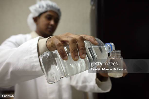 Employee test for the bacteriological content in a sample of water at the water testing laboratory, at the Camp Bastion Water Bottling Plant on July...