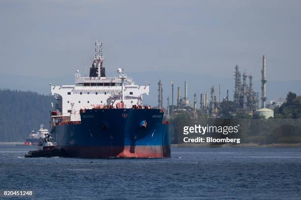 The Nord Steady oil and chemical tanker is guided by tugboats past the Chevron Canada Burnaby Refinery at the Port of Vancouver in Vancouver, British...