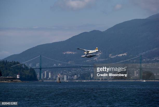 Harbour Air seaplane prepares to land on the harbour past the Lions Gate Bridge in Vancouver, British Columbia, Canada, on Tuesday, July 11, 2017....