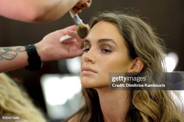 Model prepares backstage during the SWIMMIAMI Hammock 2018 Collection fashion show at WET Deck at W South Beach on July 21, 2017 in Miami Beach,...