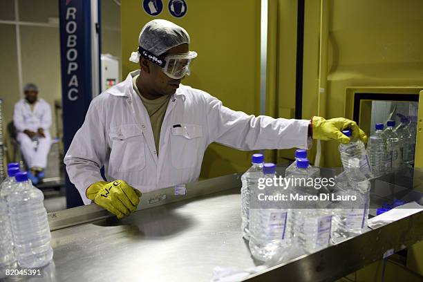 Employees work at a manufacturing plant at the Camp Bastion Water Bottling Plant on July 21, 2008 at the British Army base in Camp Bastion in the...