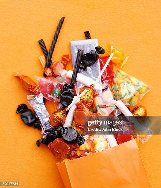 halloween candy spilling from bag - halloween candy bag stock pictures, royalty-free photos & images