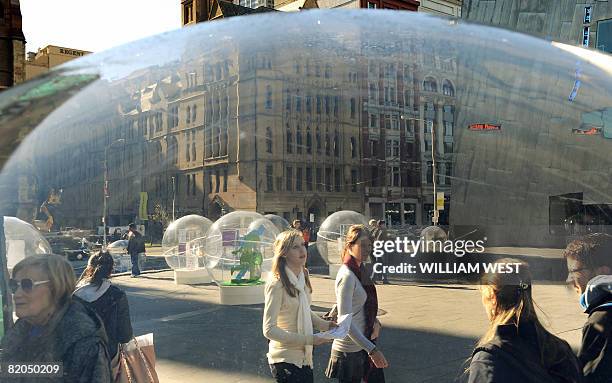 Passerbys inpect a dozen giant bubbles in Melbourne's Federation Square, which contain designs of Australia's best designers and is part of the...