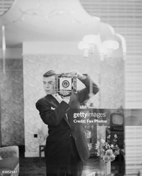 Fox Photos staff photographer captures his own image in a mirror, circa 1948.