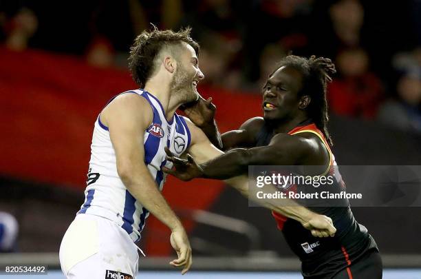 Luke McDonald of the Kangaroos and Anthony McDonald-Tipungwuti of the Bombers wrestle during the round 18 AFL match between the Essendon Bombers and...