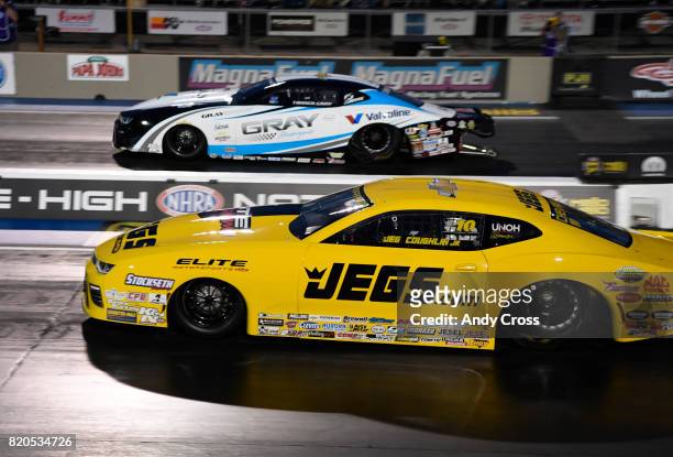 Pro stock drag racer Jeg Coughlin Jr., foreground, takes on Tanner Gray, top, on their second run of the night during the 38th annual Mopar Mile High...