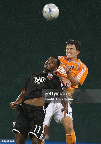 Luciano Emilio of D.C. United leans into Bobby Boswell of Houston Dynamo while going for a header during the MLS match at RFK Stadium on July 23,...