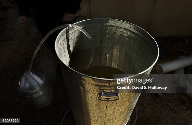 Water from an aluminimum trash can is funneled into on of the 5 gallon "Homey bucket" style devices tested at a large vehicle bomb counter measures...