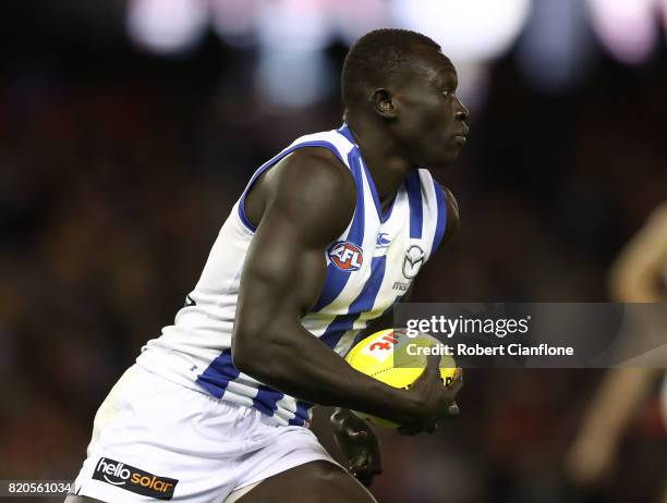 Majak Daw of the Kangaroos runs with the ball during the round 18 AFL match between the Essendon Bombers and the North Melbourne Kangaroos at Etihad...