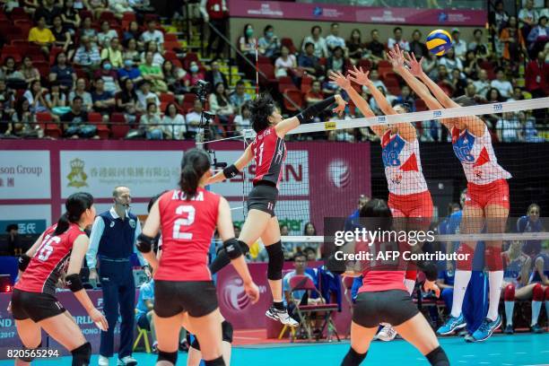 Yurie Nabeya of Japan spikes the ball past the defence of Milena Rasic and Tijana Boskovic of Serbia during their match at the Women's Volleyball...