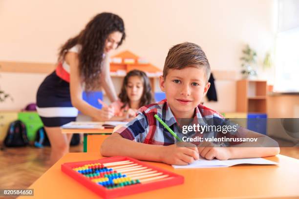 schoolboy at classroom - criança de escola primária imagens e fotografias de stock