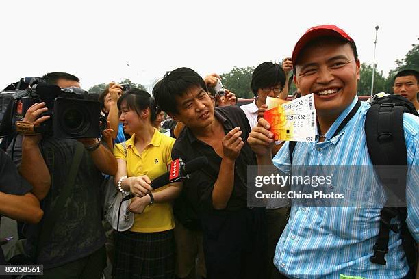 Zhu Xinyue displays his Olympic tickets after queuing two days at a ticket booth on July 25, 2008 in Beijing, China. BOCOG launched the Beijing 2008...