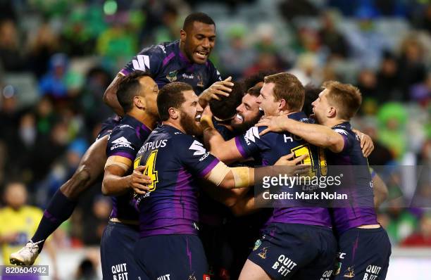 Storm players celebrate a try by Dale Finucane during the round 20 NRL match between the Canberra Raiders and the Melbourne Storm at GIO Stadium on...