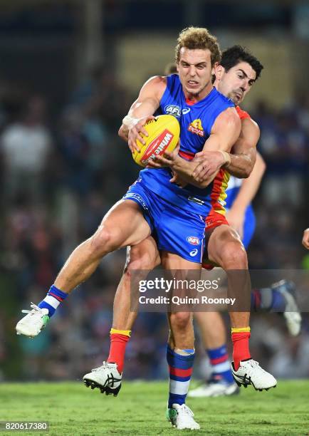 Mitch Wallis of the Bulldogs is tackled by Matt Rosa of the Suns during the round 18 AFL match between the Western Bulldogs and the Gold Coast Suns...