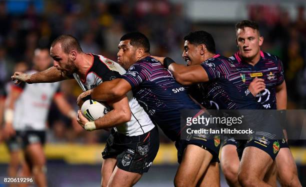 Simon Mannering of the Warriors is tackled by John Asiata and Jason Taumalolo of the Cowboys during the round 20 NRL match between the North...