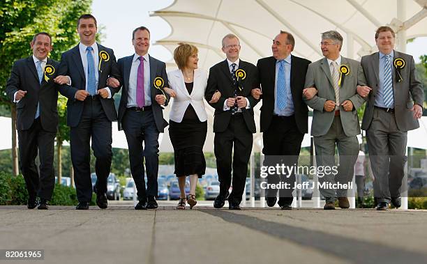 Newly elected Scottish National Party MP for the Glasgow east constituency John Mason walks with his deputy leader Nicola Sturgeon with leader Alex...