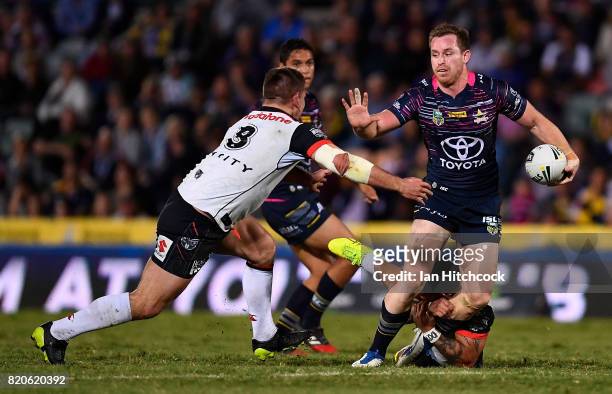 Michael Morgan of the Cowboys makes a break past Issac Luke and Jacob Lillyman of the Warriors during the round 20 NRL match between the North...