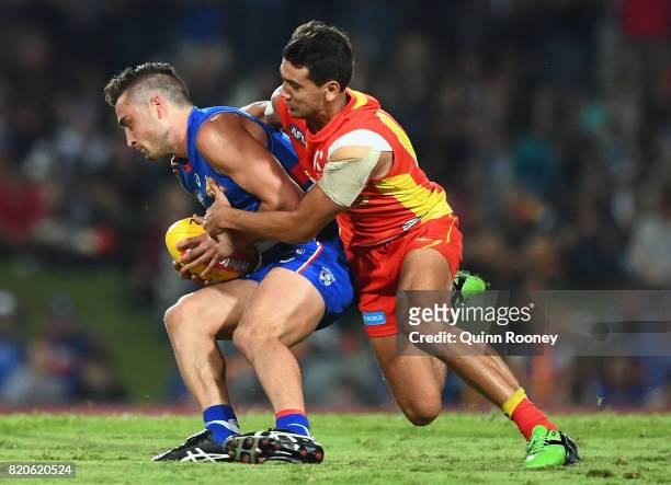 Luke Dahlhaus of the Bulldogs is tackled by Callum Ah Chee of the Suns during the round 18 AFL match between the Western Bulldogs and the Gold Coast...