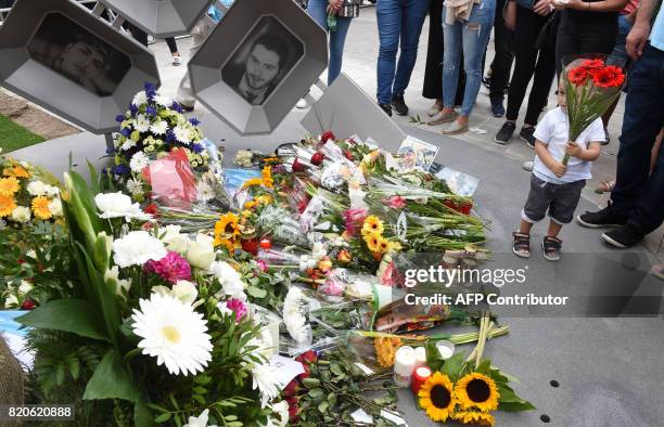 People mourn at a memorial dedicated to the victims of a shooting near the Olympia Einkaufszentrum shopping centre in Munich, southern Germany, on...