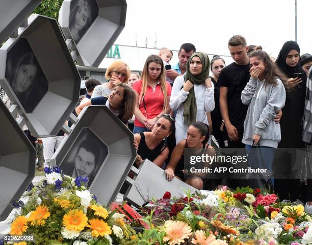 People mourn at a memorial dedicated to the victims of a shooting near the Olympia Einkaufszentrum shopping centre in Munich, southern Germany, on...