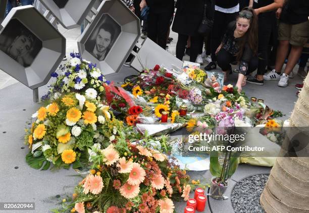 People mourn at a memorial dedicated to the victims of a shooting near the Olympia Einkaufszentrum shopping centre in Munich, southern Germany, on...