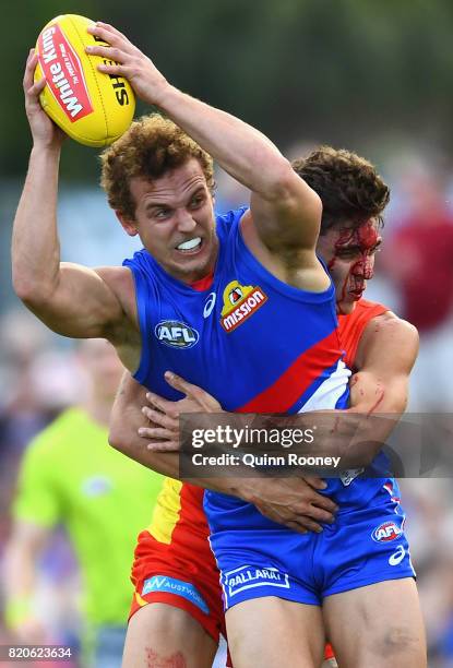 Mitch Wallis of the Bulldogs is tackled by Sean Lemmens of the Suns during the round 18 AFL match between the Western Bulldogs and the Gold Coast...