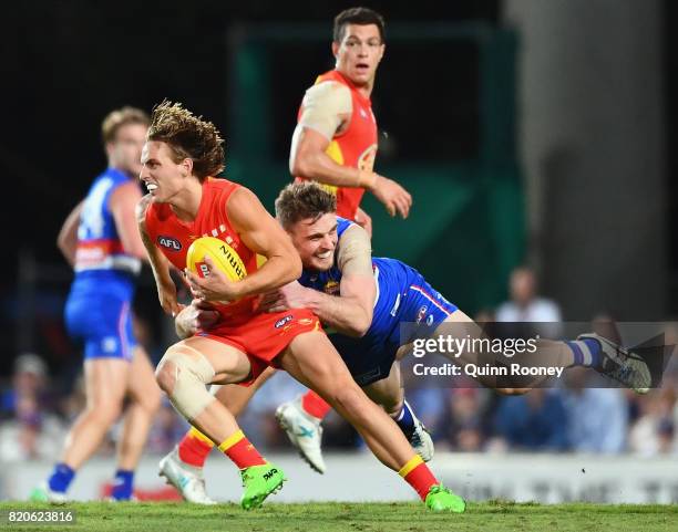 Darcy Macpherson of the Suns is tackled by Jordan Roughead of the Bulldogs during the round 18 AFL match between the Western Bulldogs and the Gold...