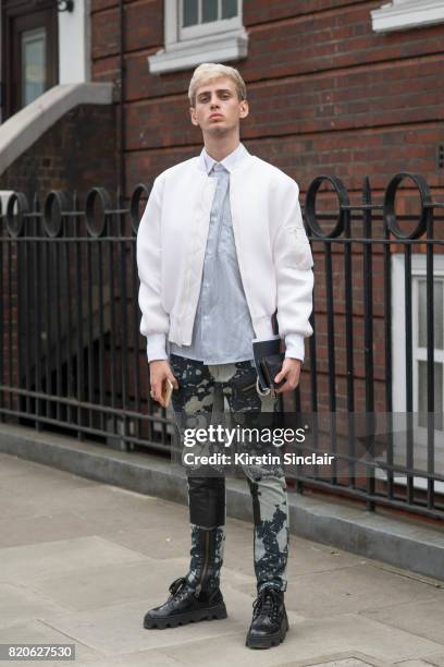 Fashion student and model Nikolas Santur wears Underground shoes, KTZ trousers, vintage shirt, Coach wallet and a CMMN SWDN jacket on day 3 of London...