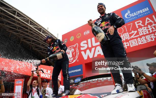 Peugeot's French driver Cyril Despres and co-driver David Castera celebrate on the podium of the 2017 Rally Silk Way in Xian, China after winning the...