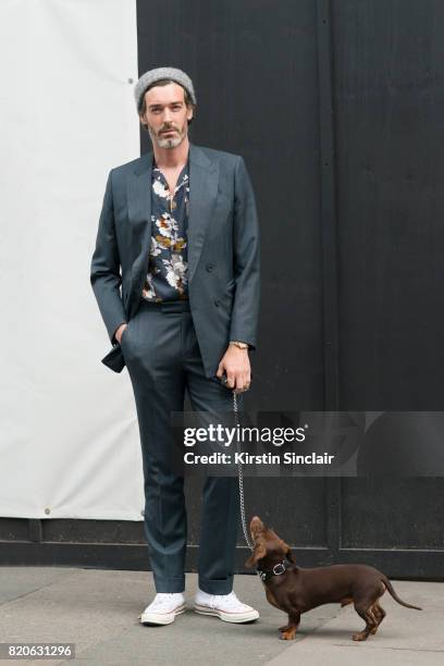 Model Richard Biedul wears a Richard James suit, River Island shirt, Converse trainers with his dog Vinnie on day 3 of London Collections: Men on...