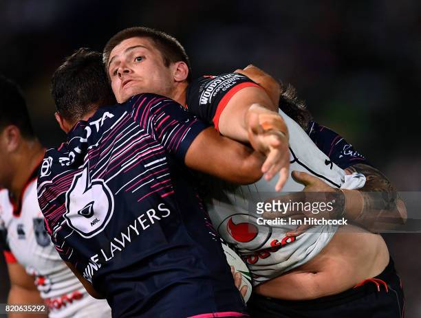 Blake Ayshford of the Warriors is tackled by Te Maire Martin of the Cowboys during the round 20 NRL match between the North Queensland Cowboys and...