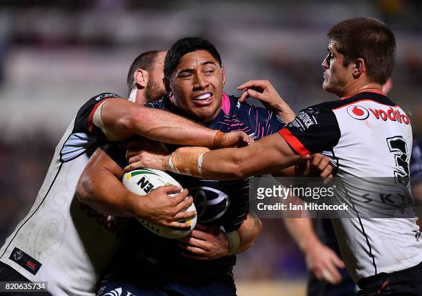 Jason Taumalolo of the Cowboys is tackled by Blake Ayshford and Simon Mannering of the Warriors during the round 20 NRL match between the North...