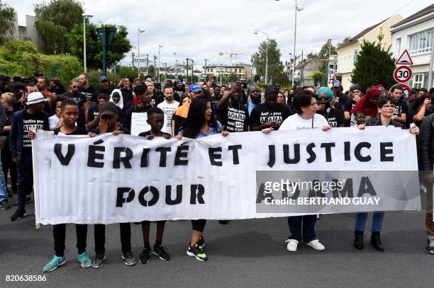 People take part in a commemorative march on July 22, 2017 in Beaumont-sur-Oise, northeast of Paris, in memory of Adama Traore, who died during his...